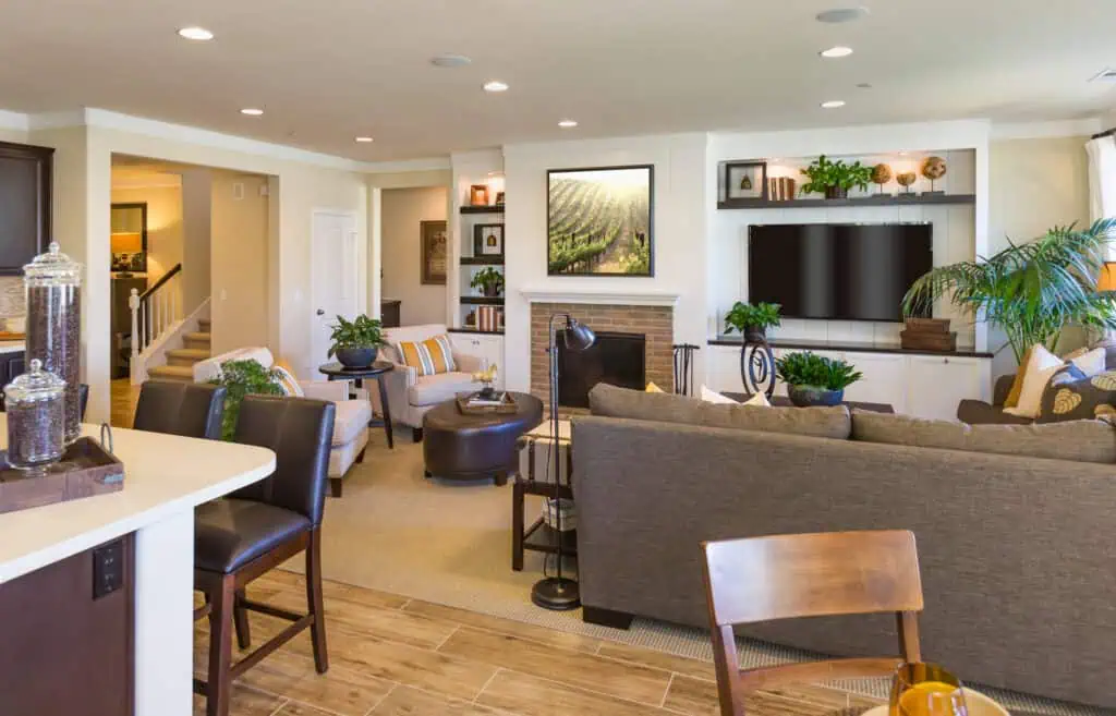 Modern living room with fireplace, flat-screen TV, and stylish furniture in a bright, open-concept h.