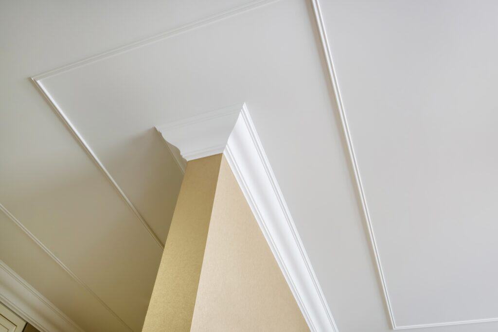 Elegant white crown molding and ceiling detail in a modern interior.