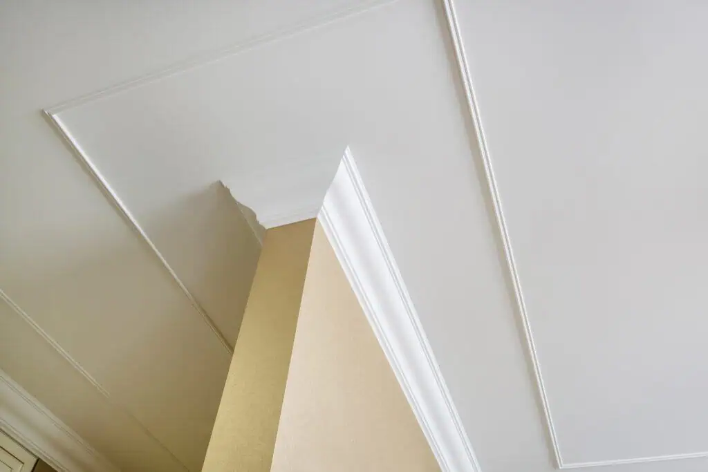 Elegant white crown molding and ceiling detail in a modern interior.