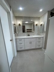 Bright modern bathroom with white vanity and large mirror for home renovation.