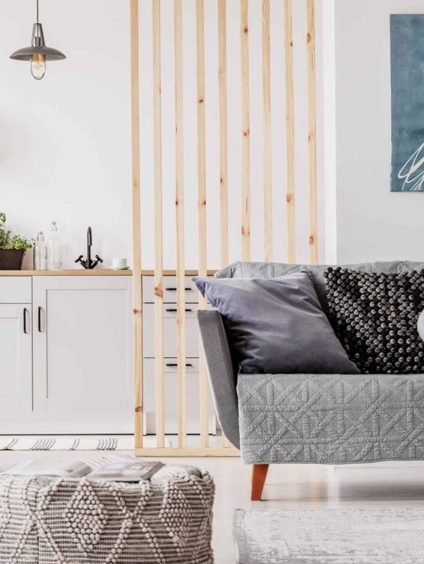 Modern living room with minimalist decor, gray sofa, and abstract wall art.